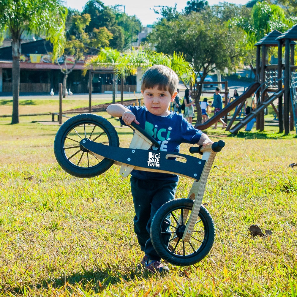 Menino carregando Biciquetinha preta lousa