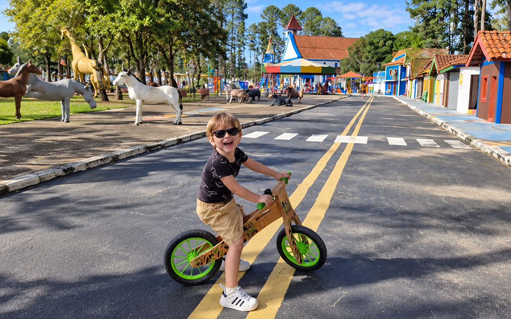 Noah andando de Biciquetinha no parque de diversões em Serra Negra, SP