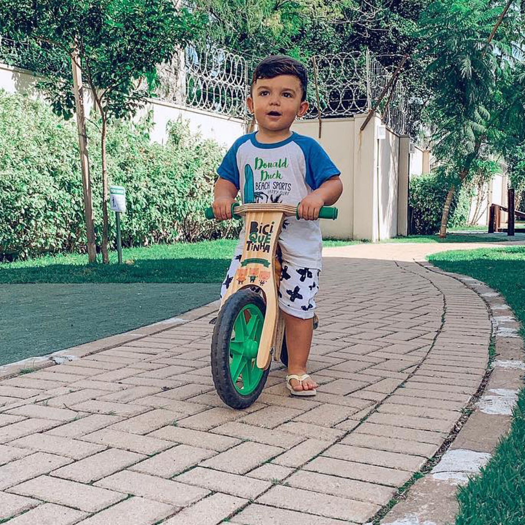 Bebê caminhando com Biciquetinha de rodas verdes